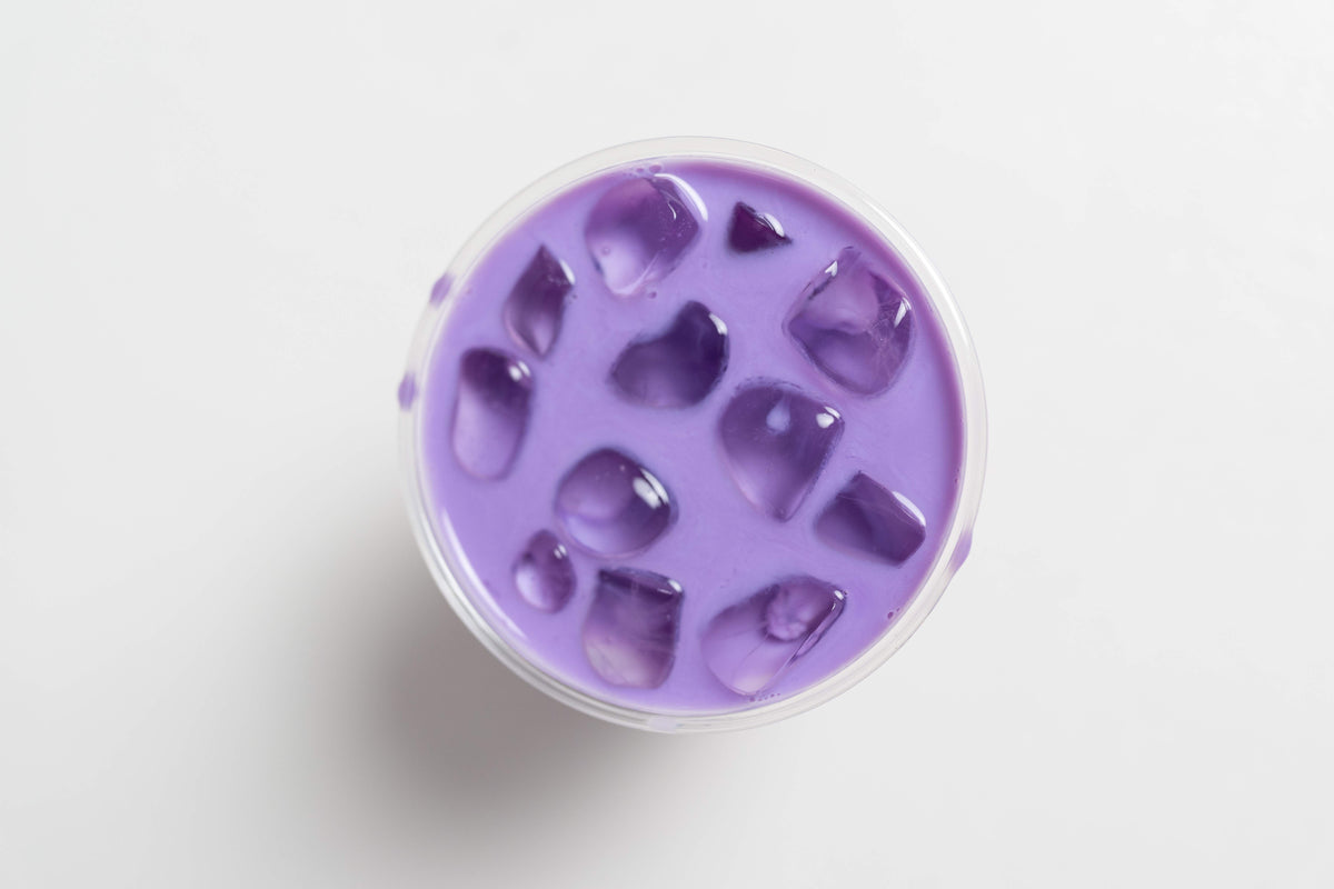 Iced ube latte in een glas, van dichtbij
