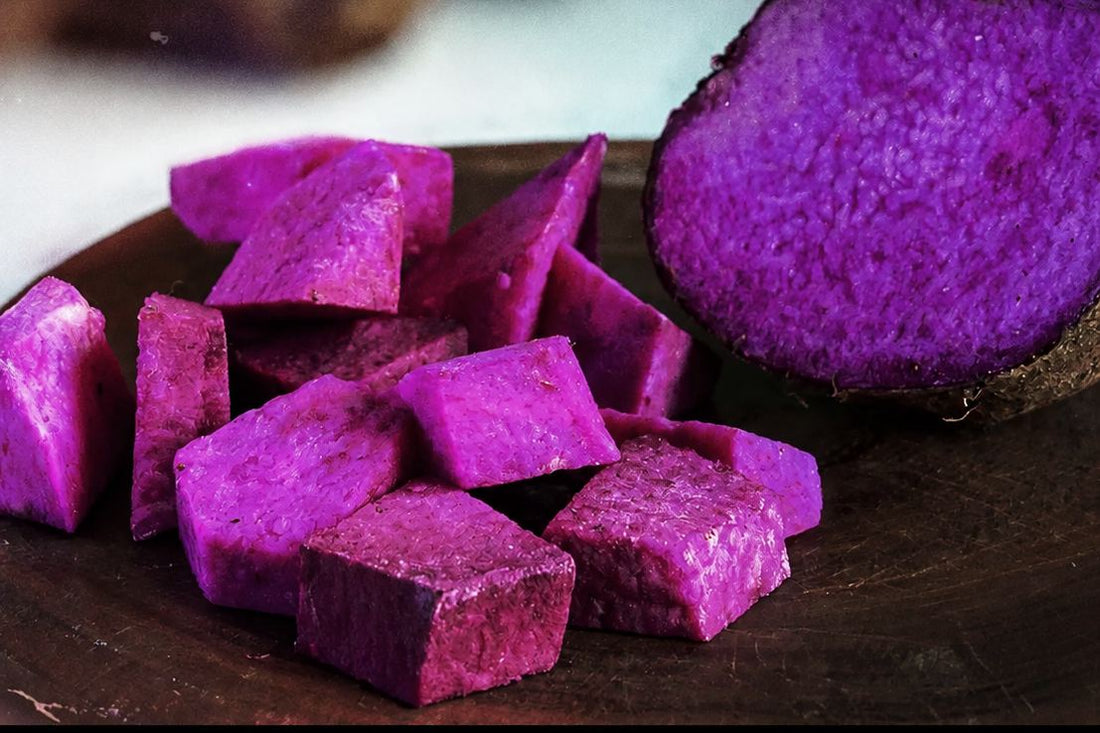 Doorgesneden ube knol met paarse blokjes op een houten bord, de paarse yam uit de Filipijnen