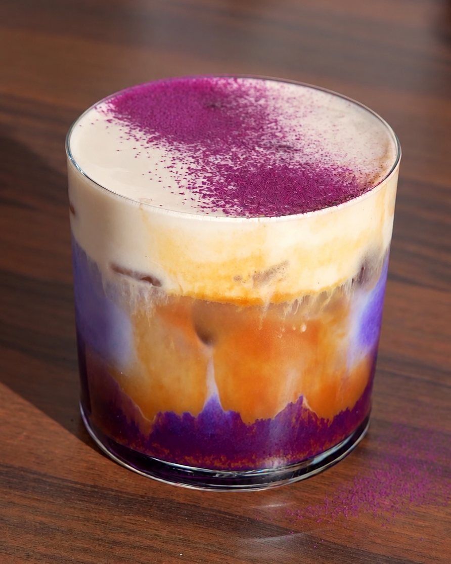 Café à l’ube en couches : ube violet au fond, espresso au-dessus et mousse de lait saupoudrée de poudre d’ube